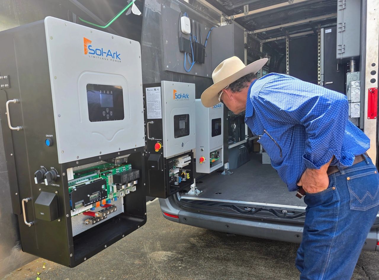 Technician inspecting Sol-Ark inverters before a solar installation